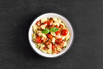 Pasta with bacon, tomato, parmesan cheese and basil leaves