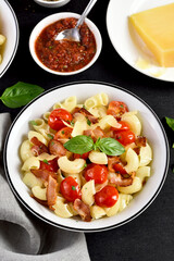 Pasta with bacon, tomato, parmesan cheese and basil leaves