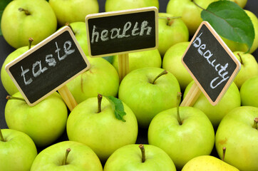 green apples and inscriptions on tablets with the words taste health and beauty