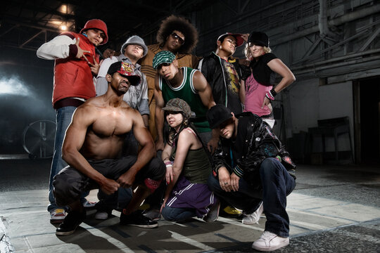 Multi-ethnic break-dancers posing in warehouse