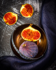still life with figs in metal bowl on grey background