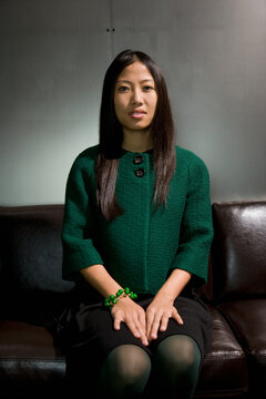 Asian woman sitting on sofa