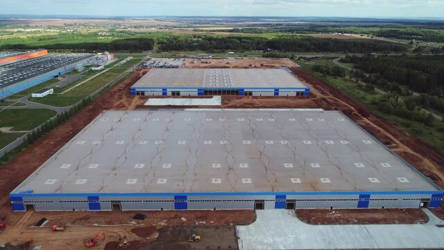 Future warehouses with flat roofs among green fields arial