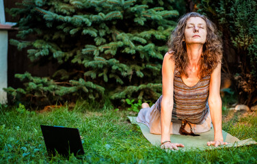 woman doing yoga in green backyard