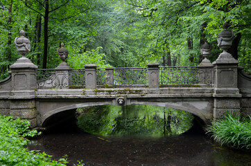 Old stone bridge in autumn over a brook in the English Garden in Munich