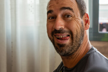 Portrait of middle-aged man with beard sticking out his tongue