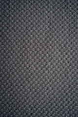 Close-up of pattern on a gray fabric. Dark dotted texture, background