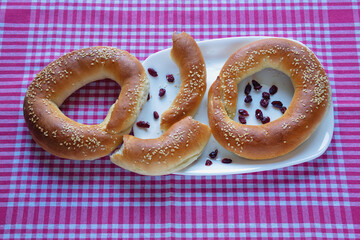 Homemade bagels with lingonberries on red and white checkered textile background