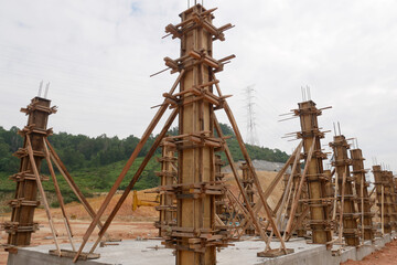 Fototapeta na wymiar KUALA LUMPUR, MALAYSIA -SEPTEMBER 19, 2020: Column timber form work and reinforcement bar at the construction site. Installed by construction workers. The structure supported by temporary wood support