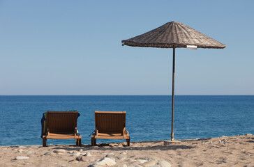 Beach Umbrella with two Sun Loungers on Beach