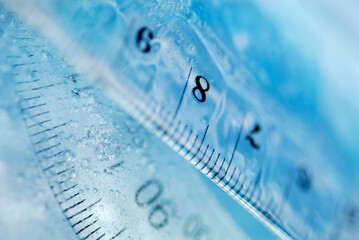 Close-up of a protractor and a ruler in water