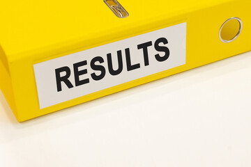 The word results on a white background with a yellow folder. Business concept