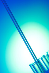 Close-up of a dropper over test tubes