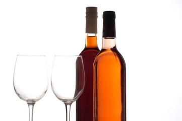 Close-up of two wineglasses with two wine bottles