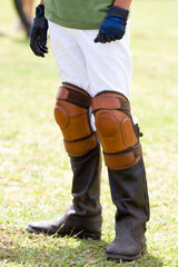 Fototapeta premium Low section view of a teenage boy wearing riding boots and kneepads 