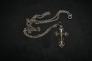Fototapeta na wymiar Cross with chain on a dark background.