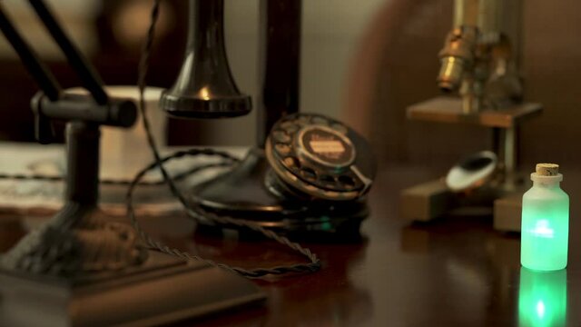 Scene dollies right to vintage scene of a bottle of radium on a desk.