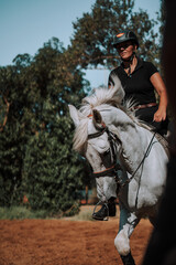 Caballo español en una hipica en andalucia con su Jinete Amazona montandolo con sus riendas y...