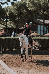 Caballo español en una hipica en andalucia con su Jinete Amazona montandolo con sus riendas y...