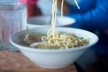Rice noodles soup with meat ball in a bowl at street food market