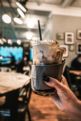 Woman holding a glass cup of hot chocolate in a cafe in Copenhagen. Warming up hot beverage on a cold Scandinavian winter day. Typical sweet and tasty traditional Christmas drink in Denmark.