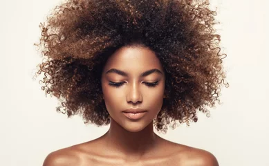 Schöne schwarze Frau. Schönheitsporträt einer afrikanisch-amerikanischen Frau mit sauberer, gesunder Haut auf beigem Hintergrund. Lächelndes schönes Afro-Mädchen. Gelocktes schwarzes Haar © Sofia Zhuravetc