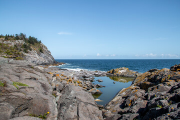 Fototapeta na wymiar Rocky coast by the edge of the ocean in summer