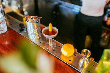 Preparación de cocktail y decoración con naranja