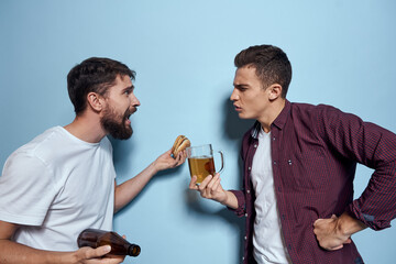 Two cheerful drunk friends drinking beer lifestyle emotions on a blue background