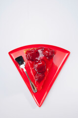 High angle view of a slice of strawberry cheesecake with a spoon