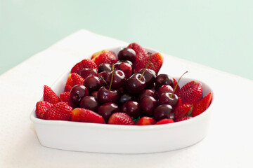 Close-up of a heart shaped bowl filled with assorted berries