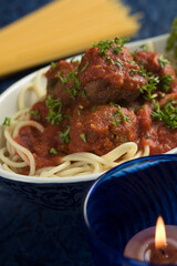 Close-up of cooked pasta with a burning candle