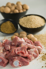 Close-up of mutton with raw potatoes and rice