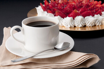 Close-up of strawberry meringue with a cup of black coffee