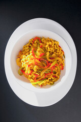 High angle view of pasta tossed in red and green peppers