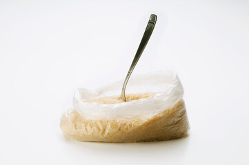 Close-up of a plastic bag of rice with a spoon