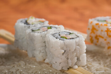 Close-up of uramaki sushi on chopsticks