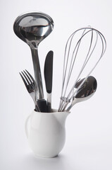 Close-up of cooking tools in a ceramic jug