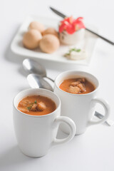 Two cups of tomato soup with bread cubes