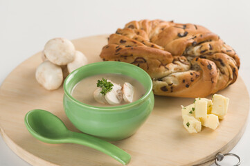 Bowl of soup served with mushroom and a loaf of bread