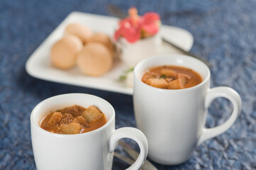 Two cups of tomato soup with bread cubes