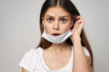 Woman with medical mask on her face displeased look emotions close-up 