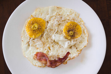 High angle view of fried eggs and bacon making a smiley face