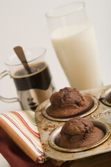 Cupcakes in a baking pan with a glass of milk