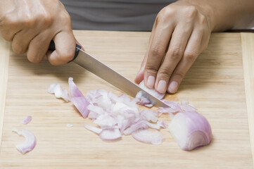 Close-up of a woman chopping an onion