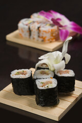 Close-up of futomaki and uramaki sushi on cutting boards
