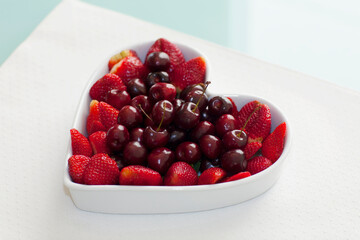 Close-up of a heart shaped bowl filled with assorted berries