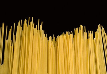 Close-up of raw spaghetti on a black background