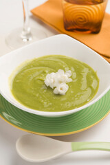 Close-up of a bowl of pea soup garnished with cream