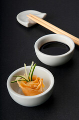 Close-up of chopsticks with soy sauce and pickled ginger